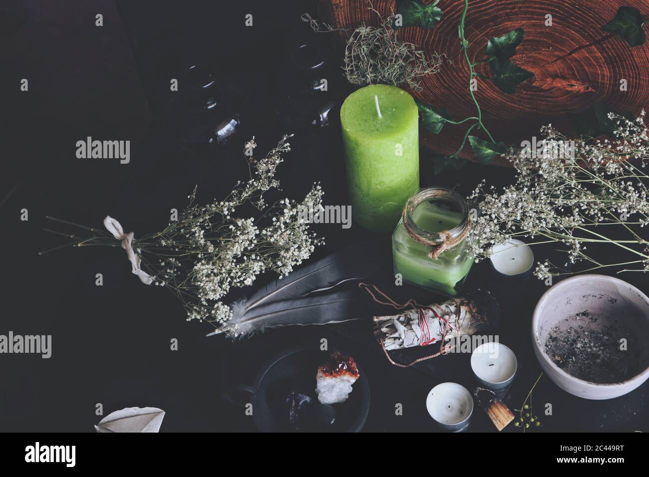 Varios hechizos encantados ingredientes de trabajo en wiccan altar de  brujas. Desorden en mesa negra con flores secas de aliento del bebé, velas  verdes y blancas Fotografía de stock - Alamy