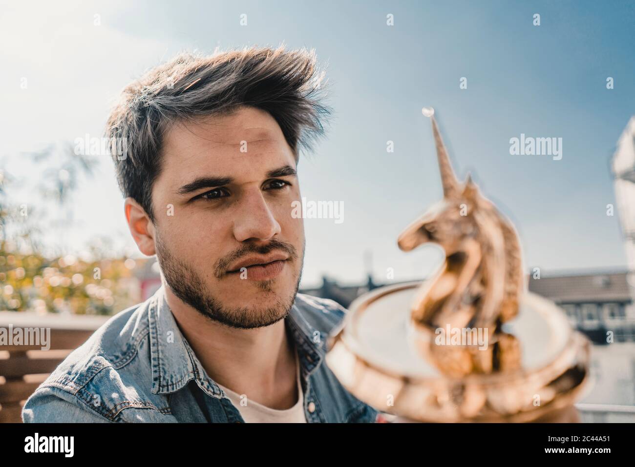 Joven empresario mirando la figura unicornio Foto de stock