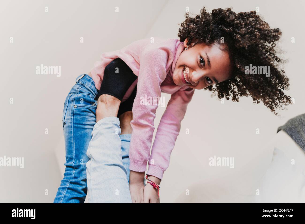 Retrato de una niña feliz jugando con su madre en casa Foto de stock