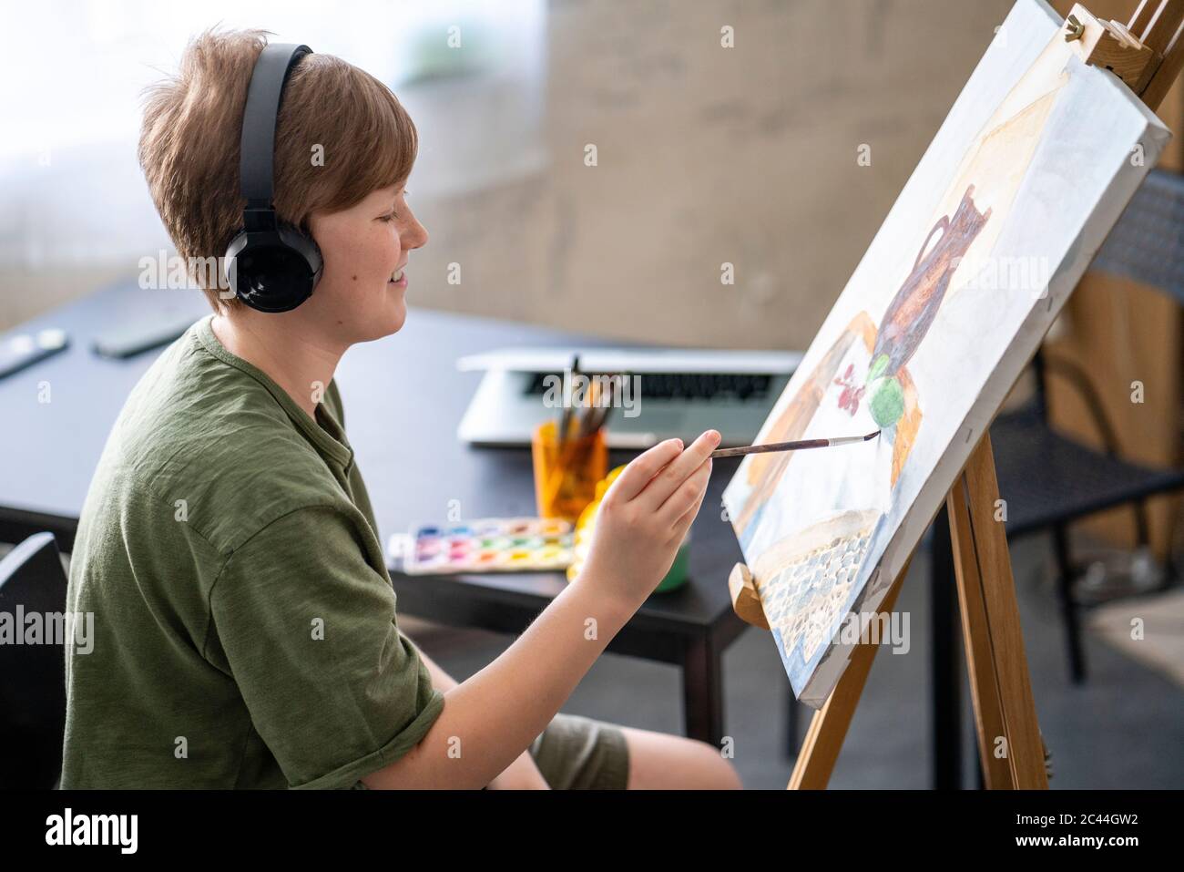Niño pintando en el caballete y escuchando música Fotografía de stock -  Alamy