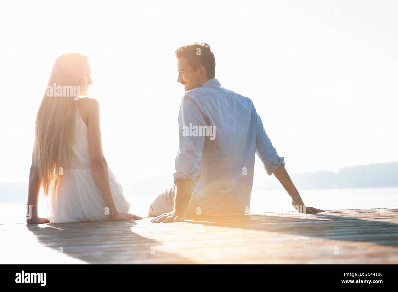 Una pareja joven se relajaba al lado del muelle Foto de stock