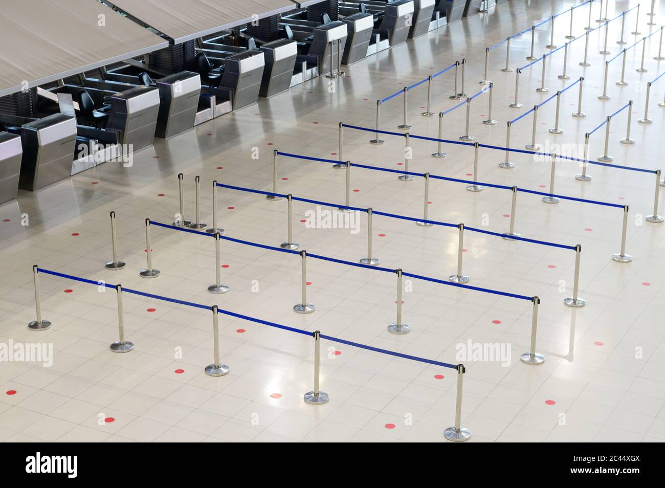 Sala terminal vacía del aeropuerto con barreras de control de multitudes Foto de stock