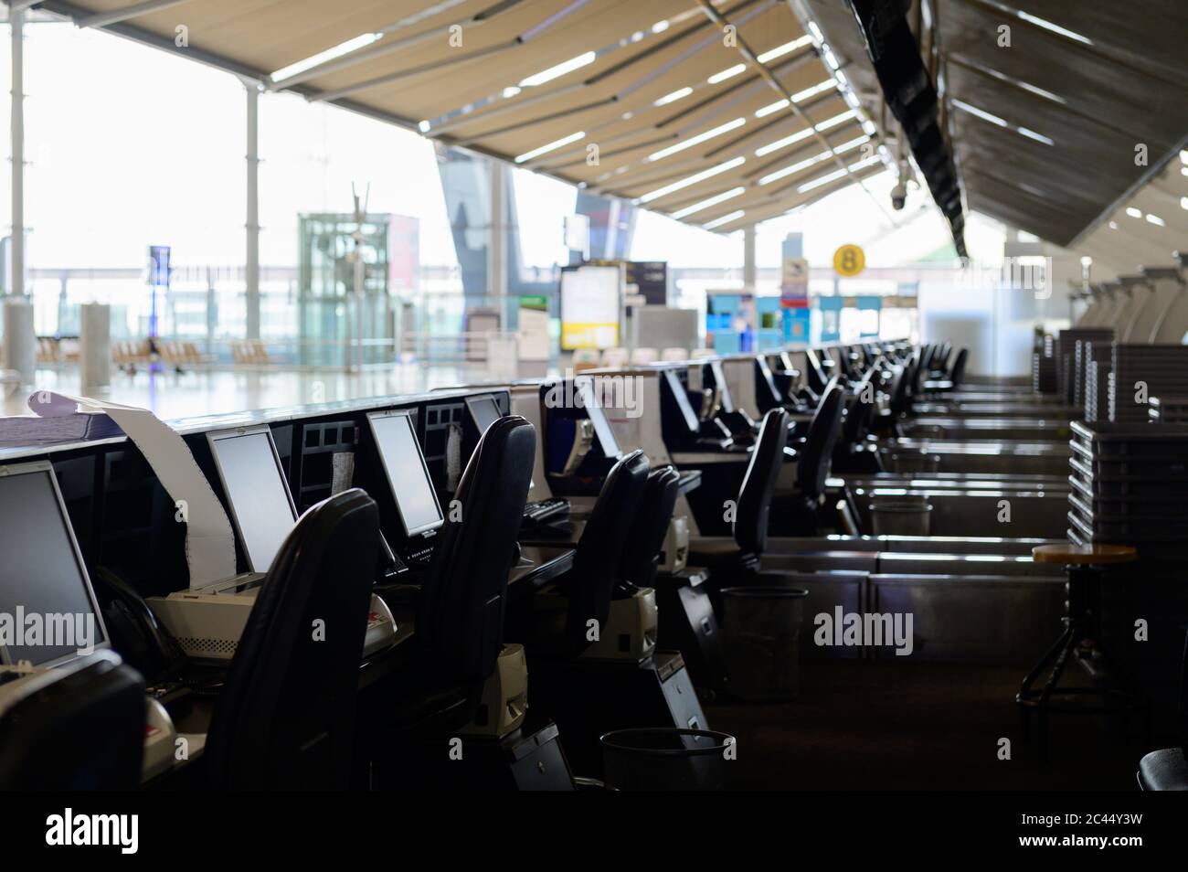 Fila de mostradores de facturación vacíos con monitores de ordenador en el aeropuerto Foto de stock