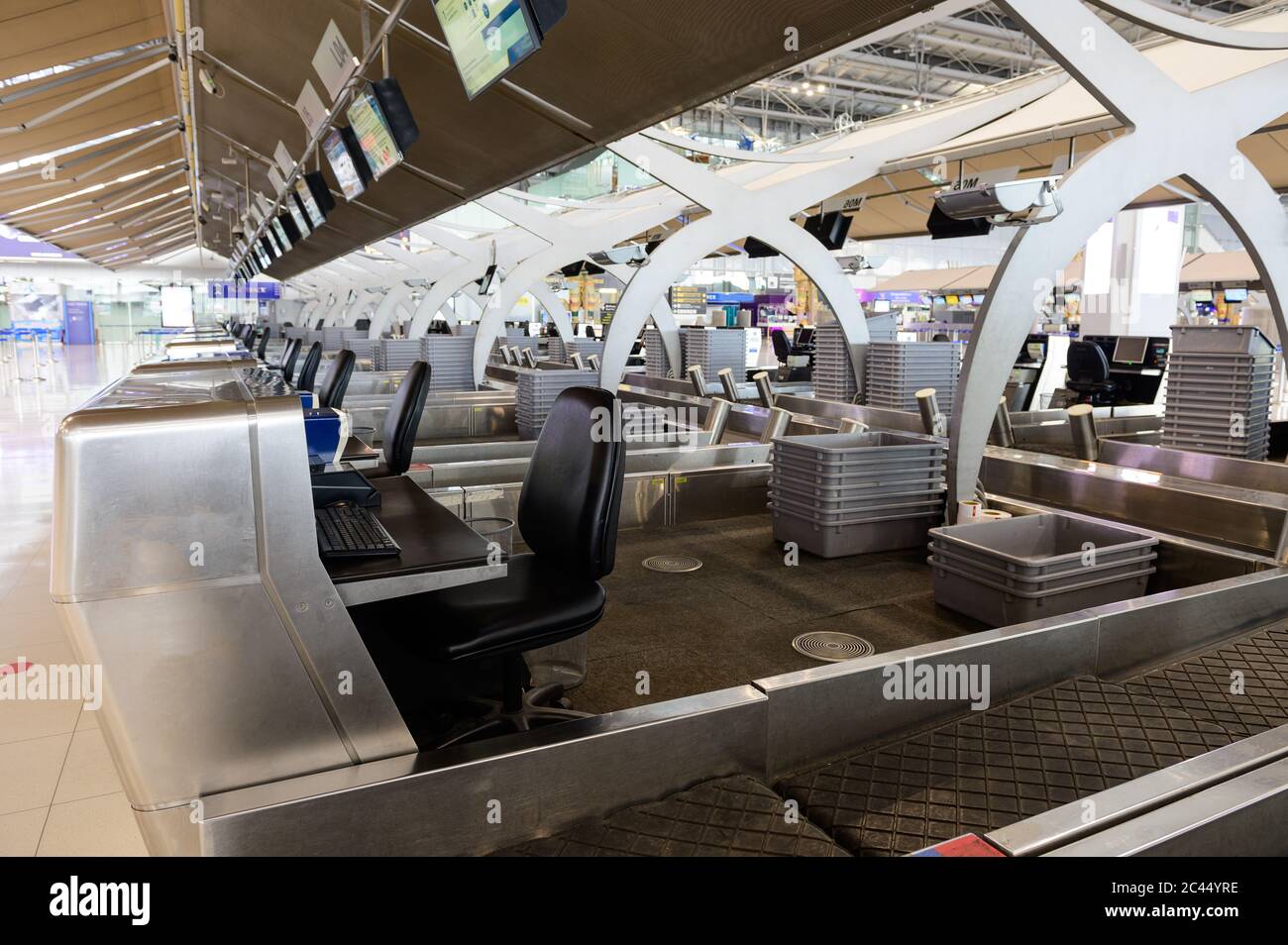 Fila de mostradores de check-in vacíos con cajas de equipaje en el aeropuerto Foto de stock
