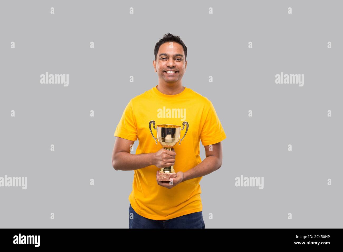 Hombre Indio sosteniendo Trofeo en manos aisladas sonriendo Foto de stock