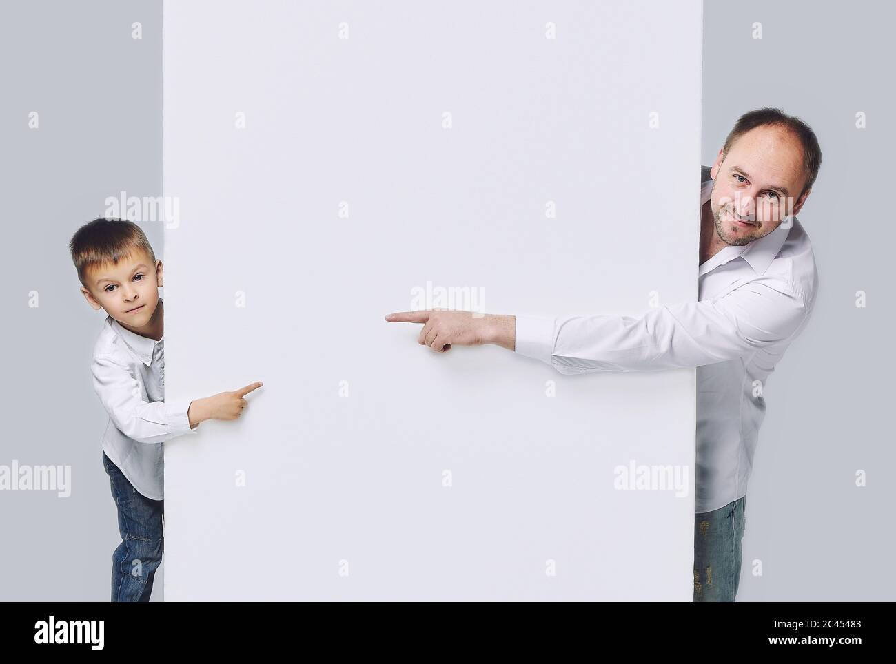 Padre e hijo se dibujan unos a otros. Apuntan a un espacio vacío.  Paternidad, psicología de las relaciones.Estudio, espalda Blanca Fotografía  de stock - Alamy