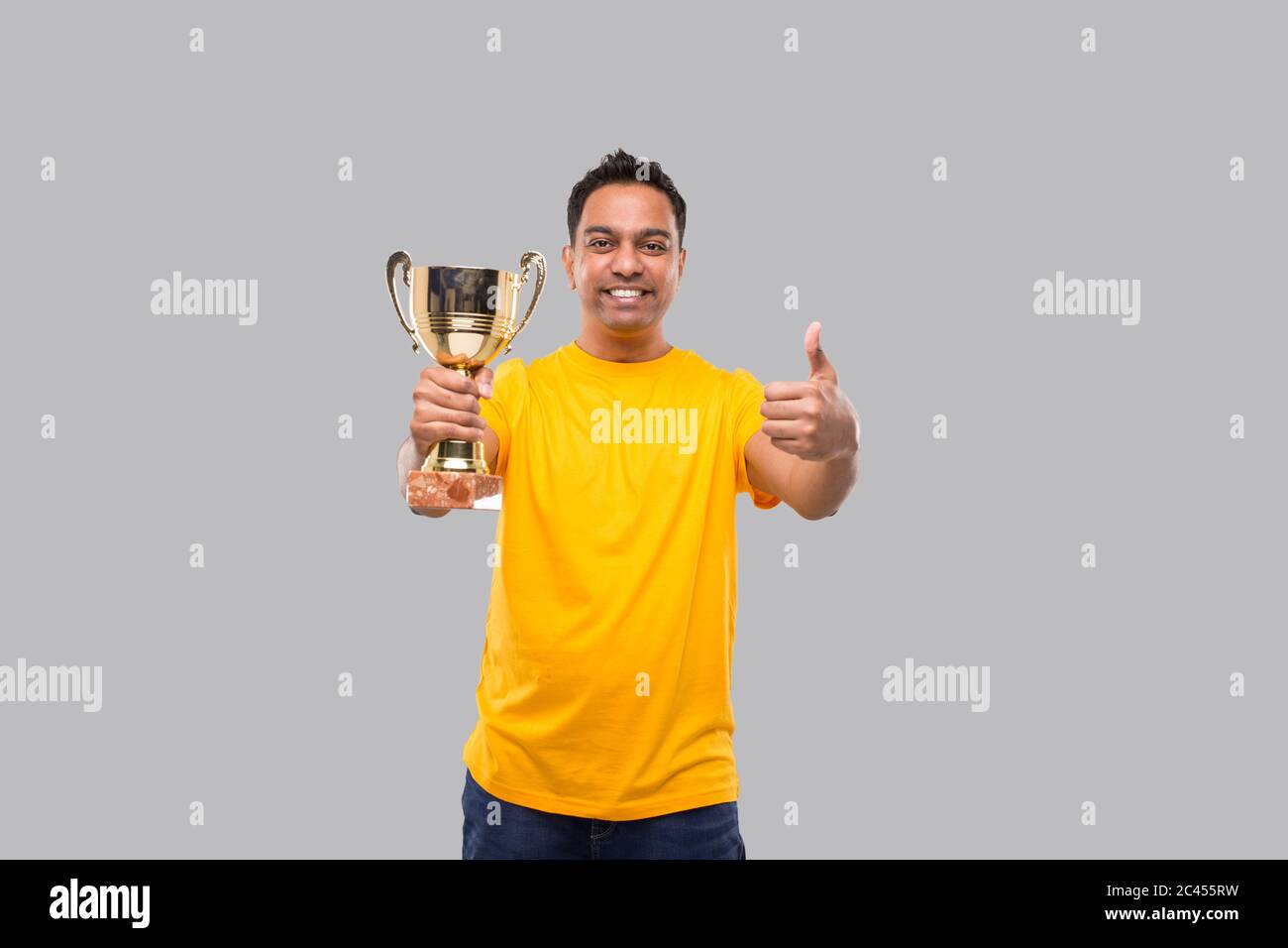 Trofeo de la mano del hombre indio mostrando Thumb Up Smilling aislado Foto de stock