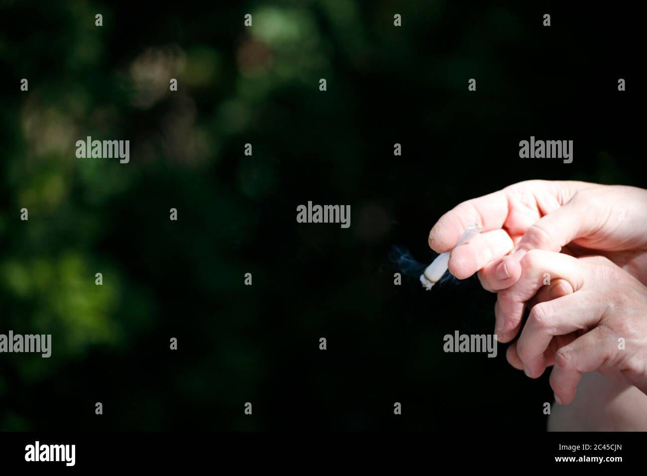 La mano sostiene un cigarrillo Foto de stock