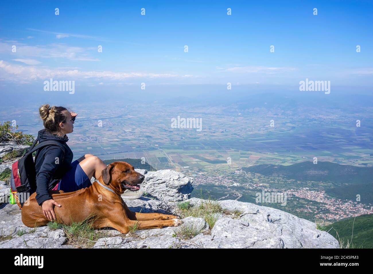 Chica con un perro rhodesian ridgeback en las montañas. Viajar con una mascota. Ama a los animales ama a mi mascota Foto de stock