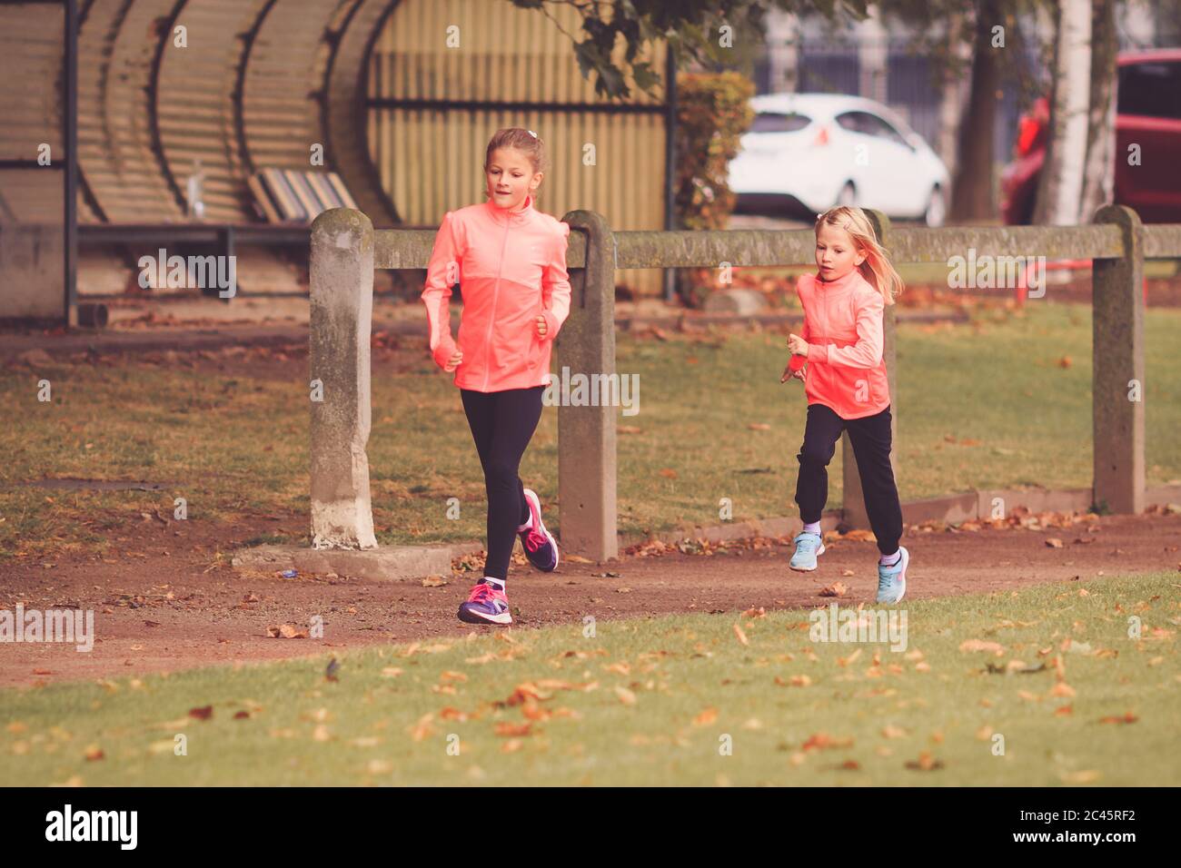 Dos niñas corriendo en la pista de carrera atlética Foto de stock