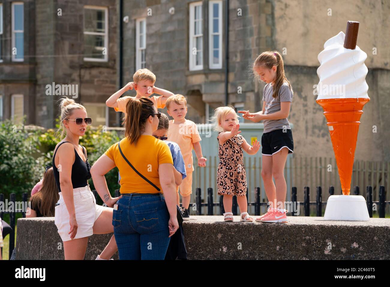 Portobello, Escocia, Reino Unido. 24 de junio de 2020. Con el sol y las temperaturas de 24C, la playa y el paseo marítimo en Portobello fuera de Edimburgo estaban ocupados con el público que disfrutaban de la libertad de una relajación de la covid-19 cierre. La furgoneta de helados tenía un cono grande para atraer a los clientes. Iain Masterton/Alamy Live News Foto de stock