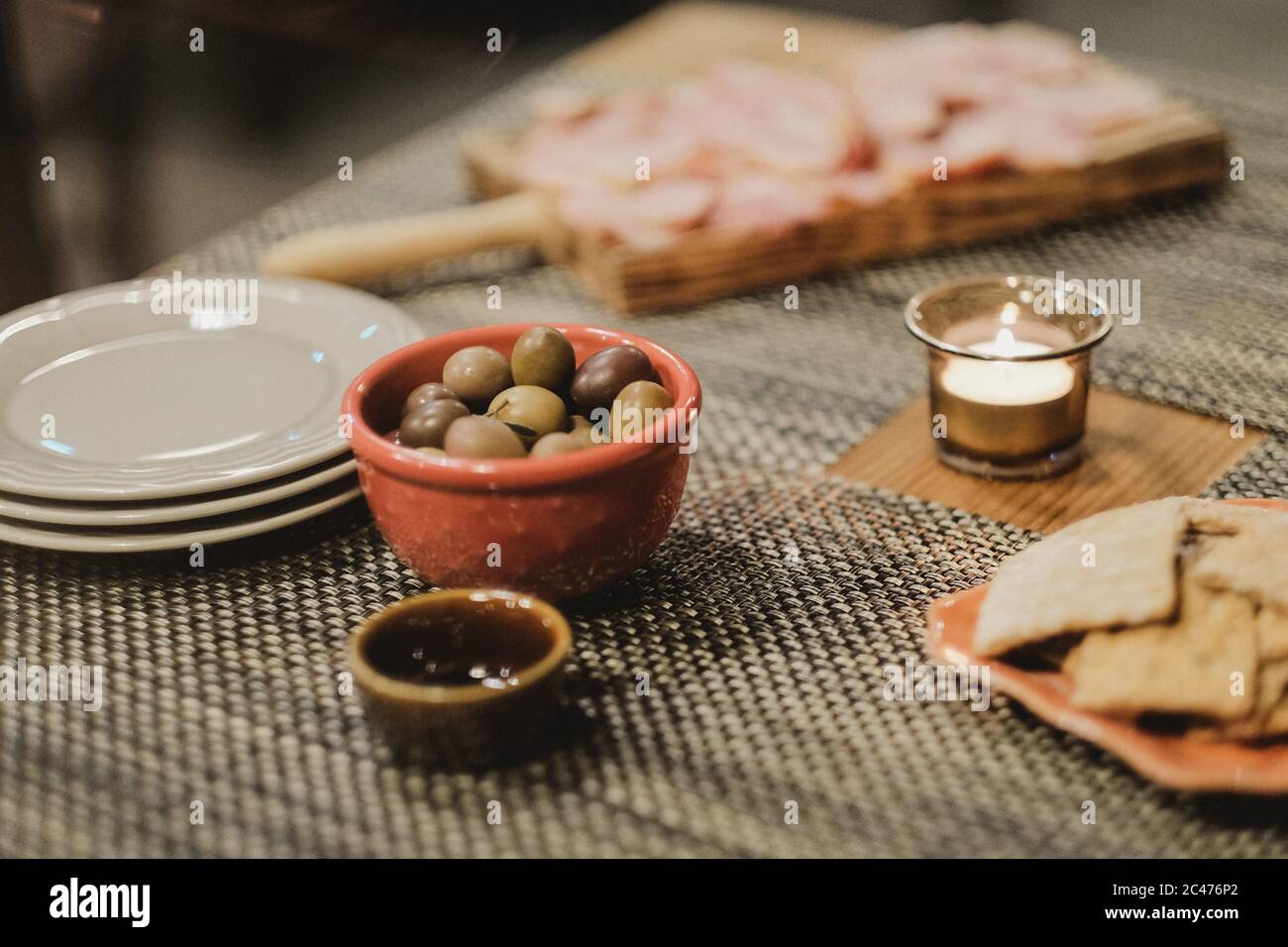 Primer plano de una comida, incluyendo aceitunas en Niza platos de cerámica  junto a una vela iluminada Fotografía de stock - Alamy