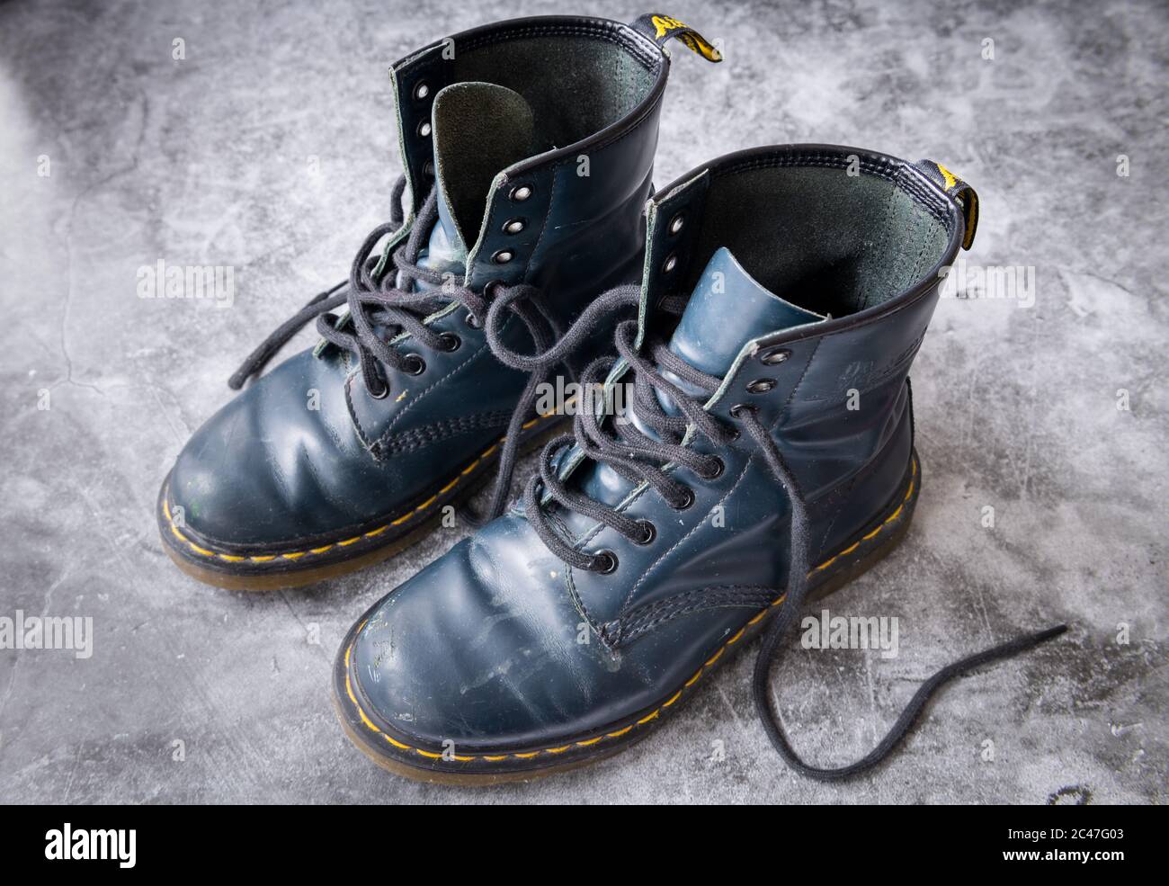 pedal Sentimental apodo Un par de botas de cuero negro Dr. Martens con cordones de zapato negro en  un fondo gris Fotografía de stock - Alamy