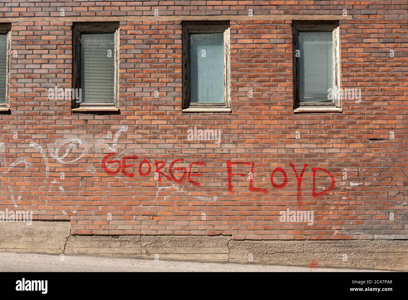 George Floyd spray pintado de rojo en una antigua pared de ladrillo en el distrito de Munkkisaari de Helsinki, Finlandia Foto de stock
