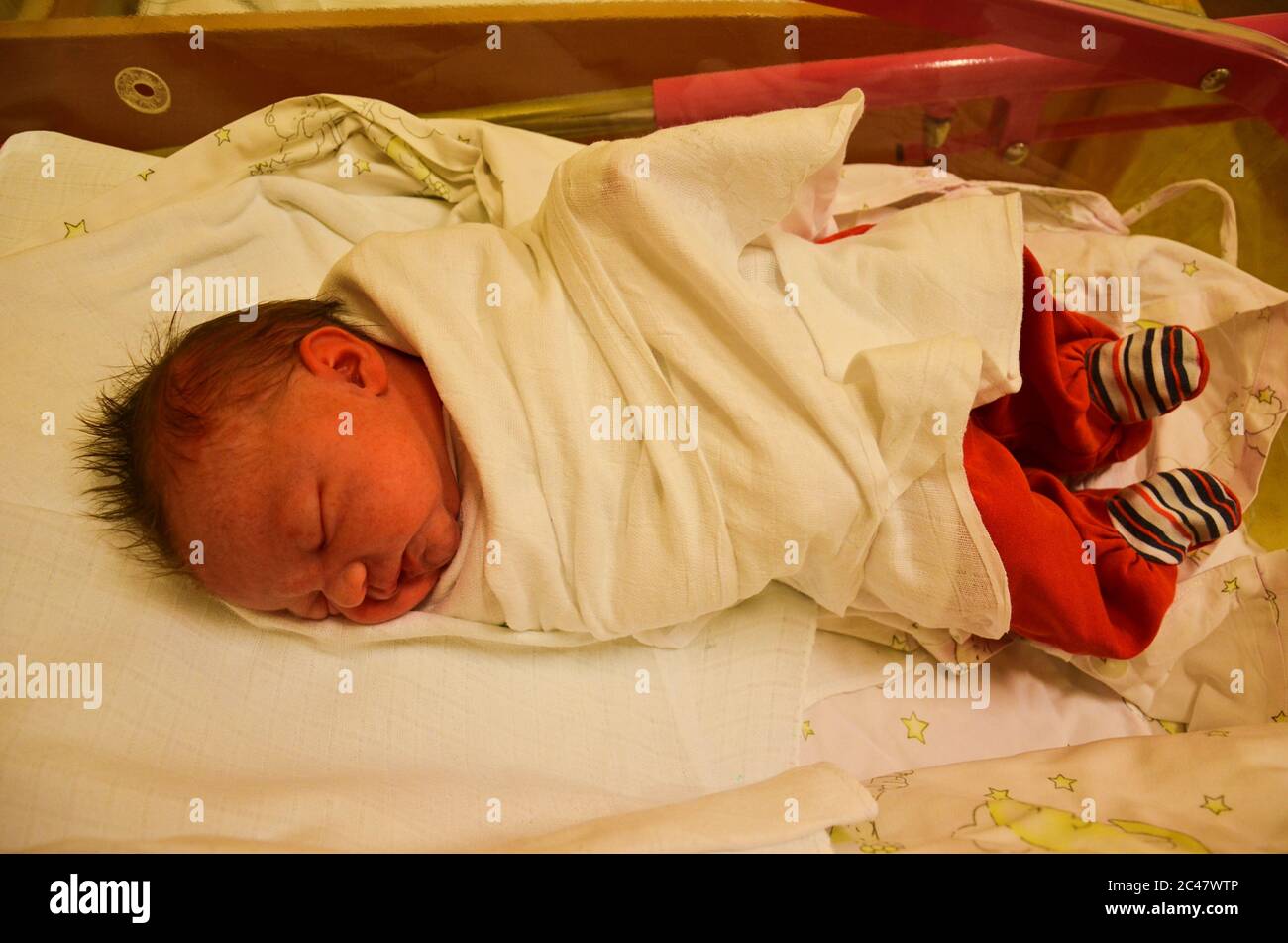 Recién nacido - niña en un hospital. Bebé recién nacido - 3,5 horas de edad  - con ropa de abrigo Fotografía de stock - Alamy