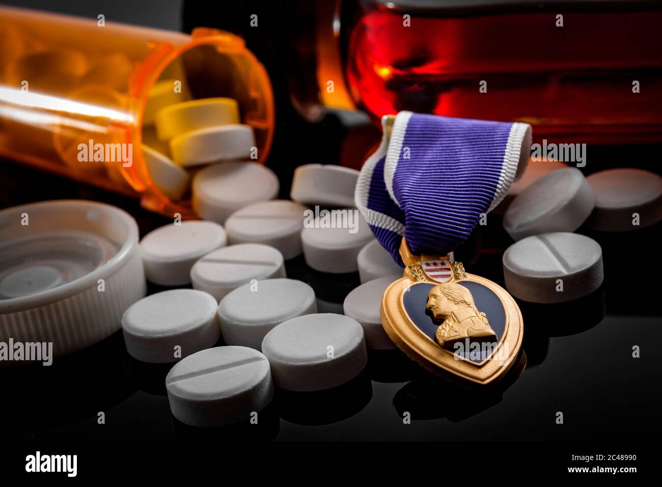 Pastillas de prescripción, una botella de alcohol y una medalla de corazón púrpura, que ilustra la realidad de muchos veteranos que luchan con PTSD y reincorporación social Foto de stock