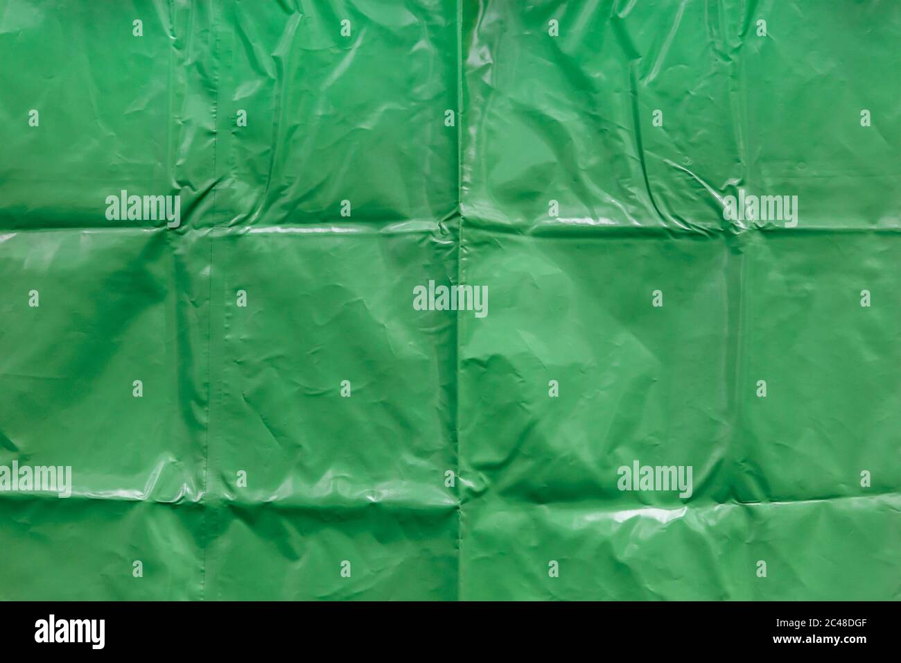 textura suave y brillante de lona y pliegues de vinilo verde liso Foto de stock