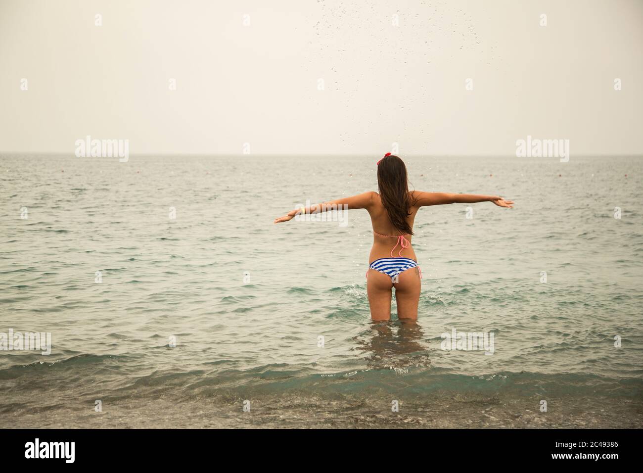 Mujer joven delgada caminando en el mar.joven camina en el agua fría en la  playa Fotografía de stock - Alamy