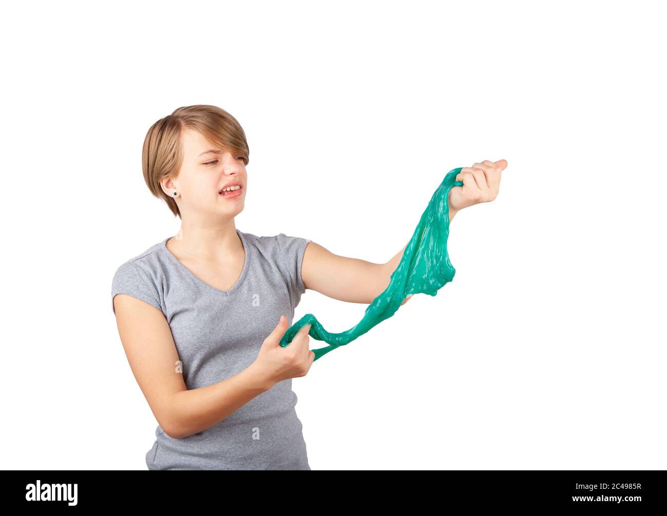 La limo es asquerosa: Una chica joven que se queja mientras aprieta una limo verde parece una moza. Estudio aislado sobre fondo blanco. Foto de stock