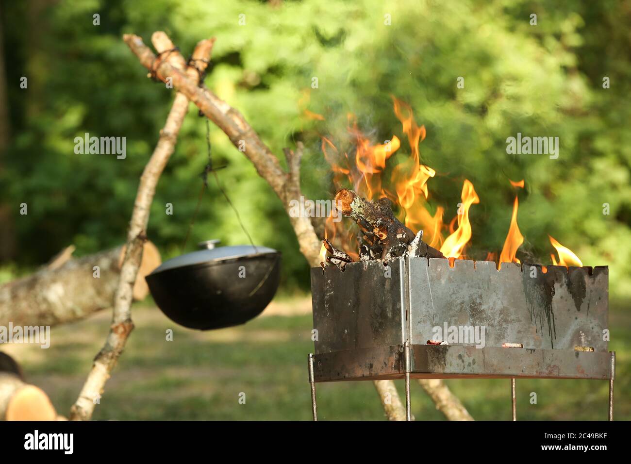 Cocinar carne al aire libre en una olla de hierro fundido. Actividades al  aire libre en verano. Camping vacaciones familiares. Comida cocinada en  carbones Fotografía de stock - Alamy
