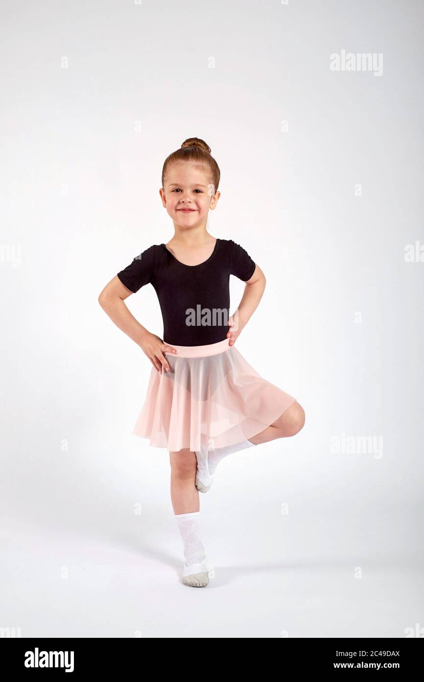 Una niña vestida con uniforme de baile está bailando sobre un fondo blanco  en el estudio Fotografía de stock - Alamy