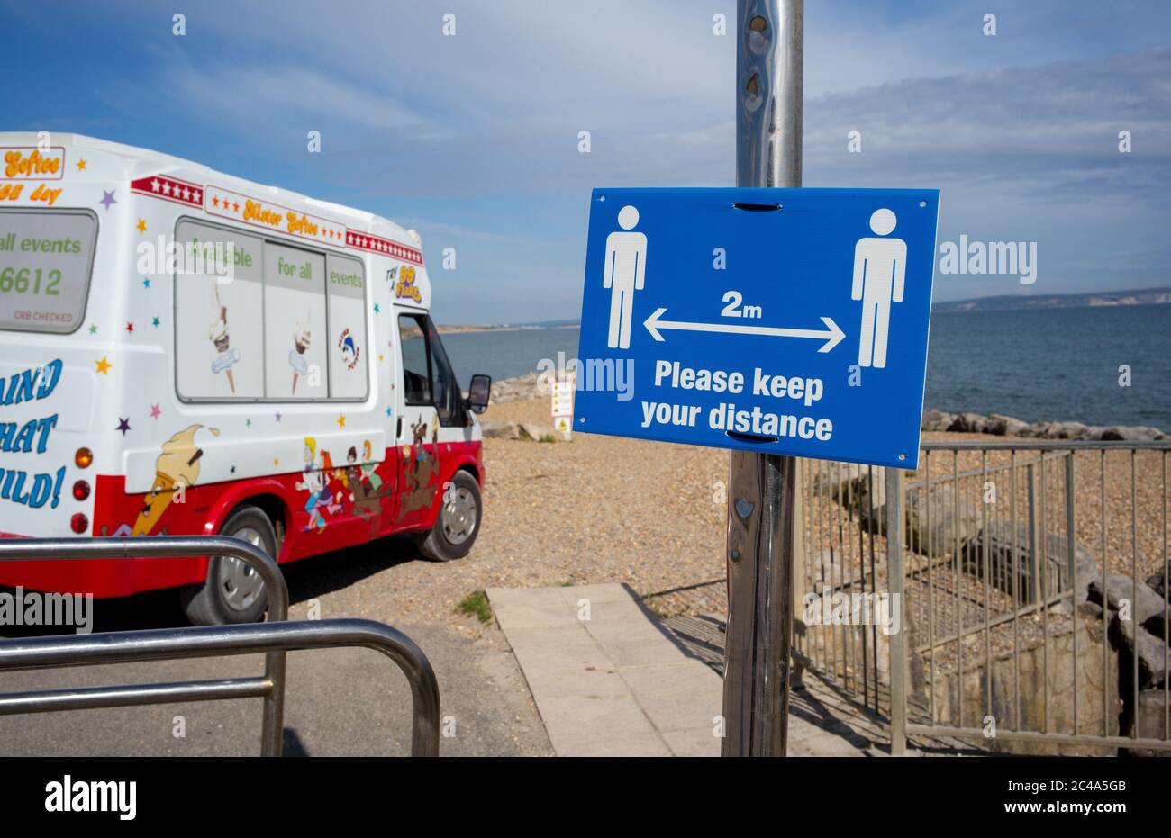 A dos metros manténgase a distancia señal de distanciamiento social en la playa de highcliffe, bournemouth. Foto de stock