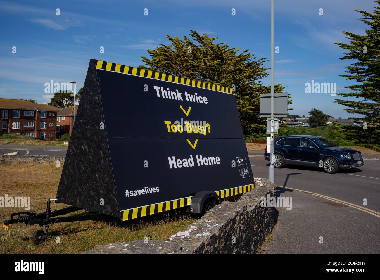 Piense dos veces, demasiado ocupado cabeza de la señal de inicio en el aparcamiento de highcliffe playa cerca de Bournemouth Inglaterra. En un intento de detener a la gente hacinando la playa. Foto de stock