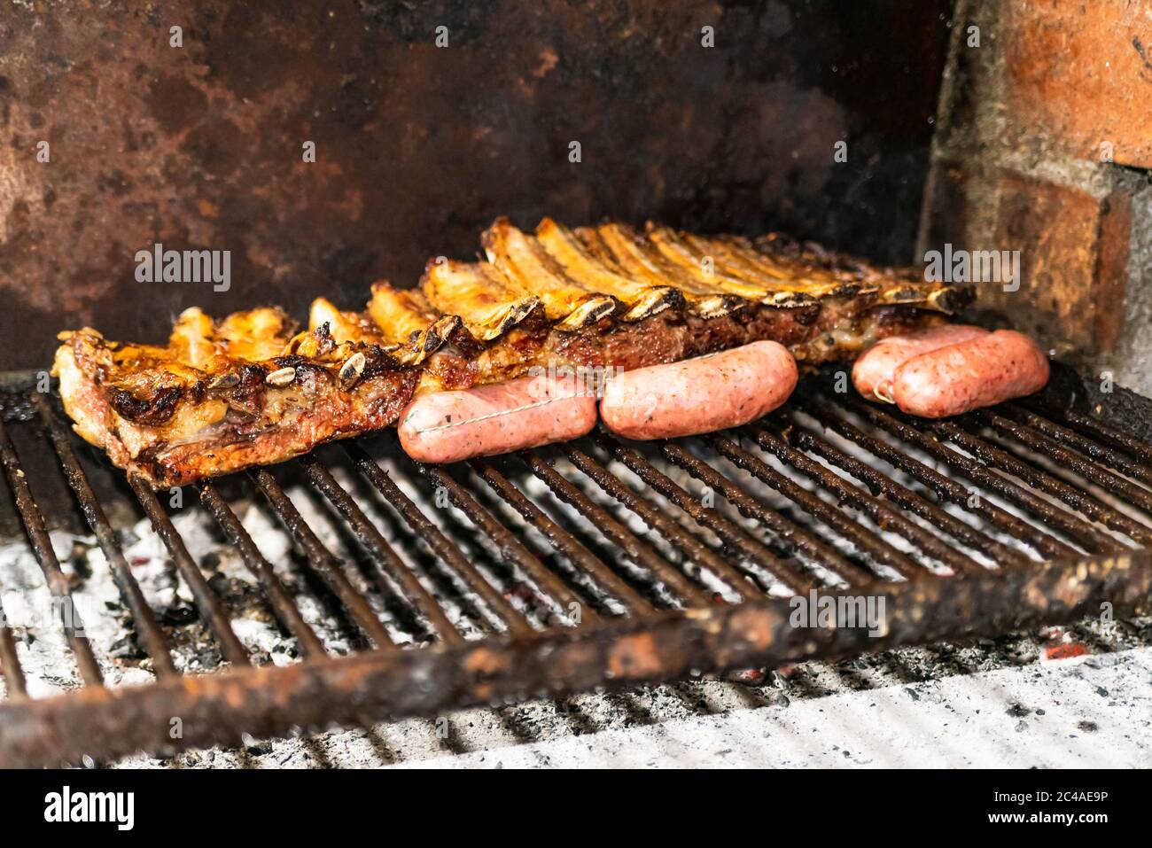 Parrillada Argentina hacer carbón vivo (sin llama), carne 'asado', pan,  'Chorizo' y costillas de ternera a la parrilla con un estante caliente, de  cerca Fotografía de stock - Alamy