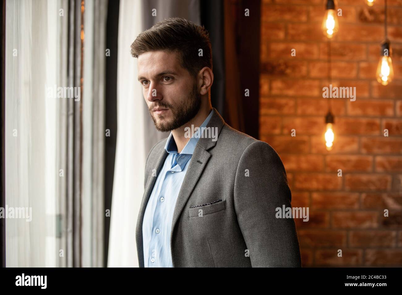 Hombre de negocios pensando en la oficina mirando a través de la ventana. Foto de stock