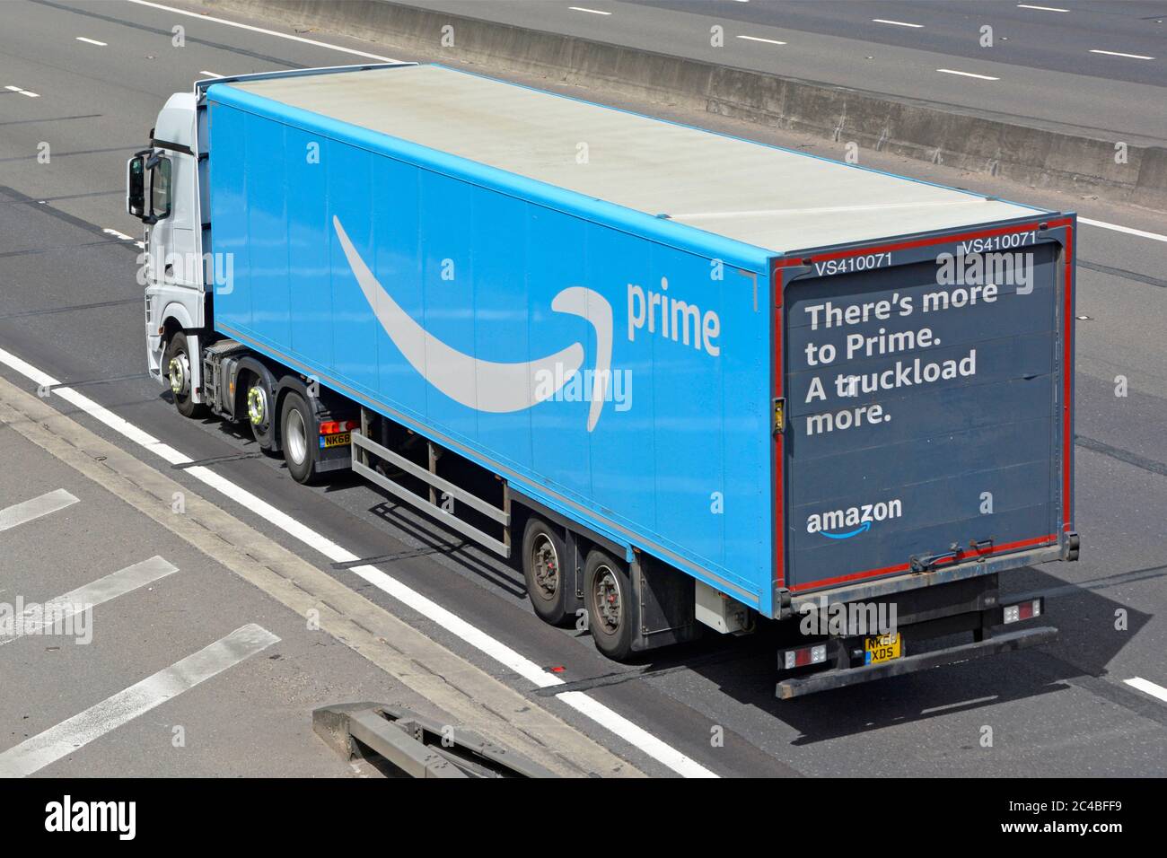 Vista aérea lateral y trasera de camión blanco azul cadena de suministro  Amazon remolque articulado con la publicidad en la puerta trasera de viaje  en la autopista del Reino Unido Fotografía de