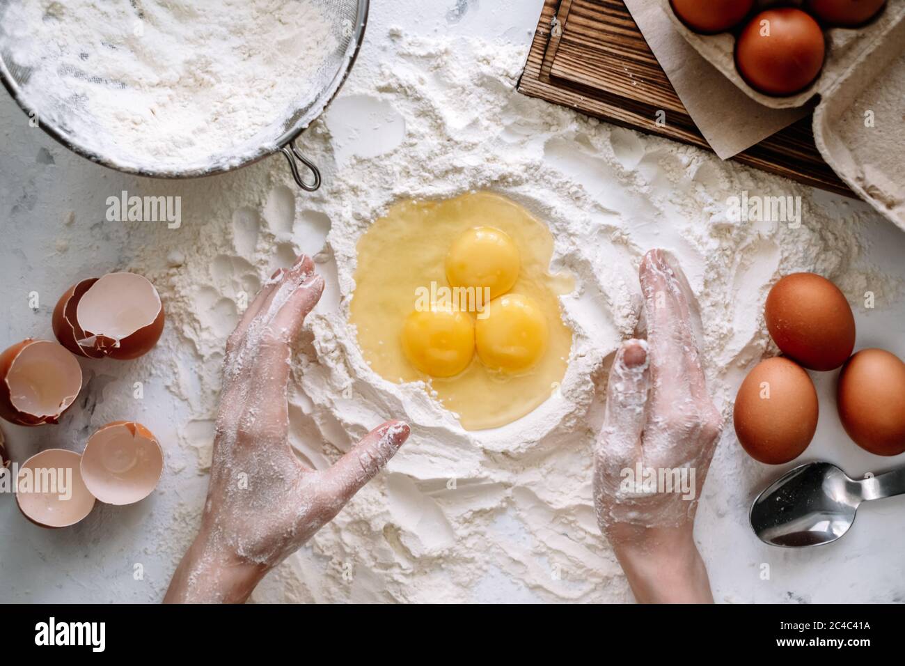 Mujer cocinando masa. Huevos de pollo en harina sobre la mesa de la cocina, ingredientes Fotografía de stock - Alamy Mujer cocinando masa. Huevos de pollo en harina sobre la mesa de la cocina, ingredientes Fotografía de stock - Alamy