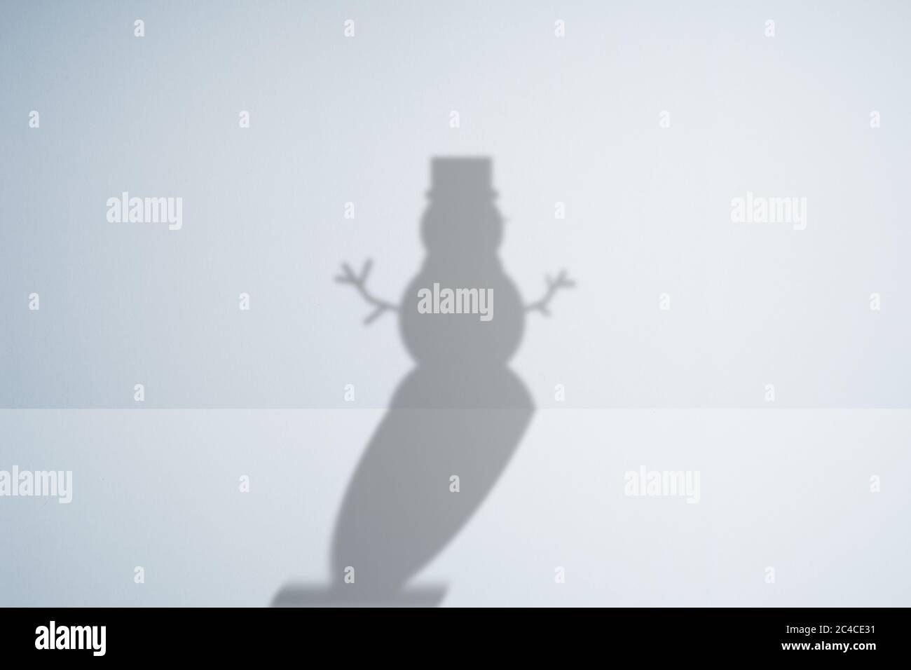 la sombra de un muñeco de nieve sobre un fondo blanco. Foto de stock