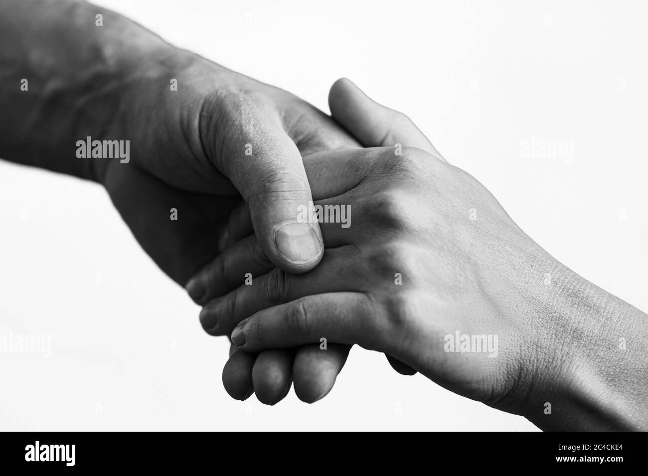 Foto en blanco y negro. Dos manos prestan una mano de ayuda a un amigo Foto de stock