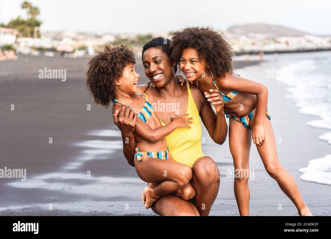 Hermanas africanas hijas en la playa con madre sonriente - familias negras que se divierten en verano - vacaciones, viajes y felicidad estilo de vida Foto de stock