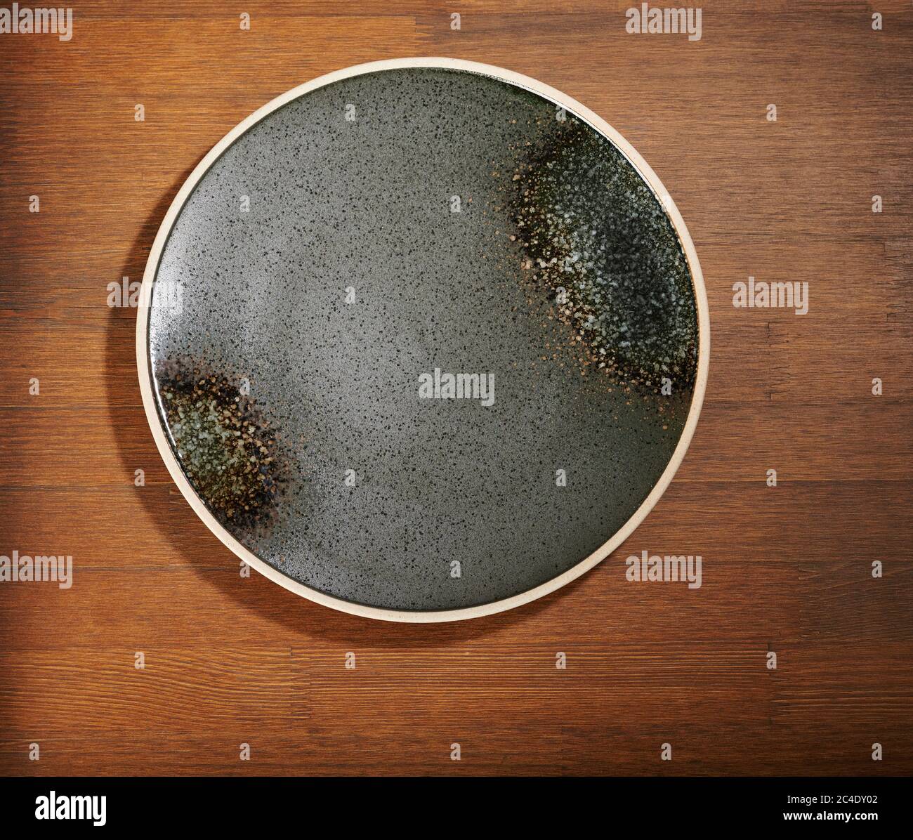 Plato vacío gris grungy sobre la vista superior sobre una mesa de madera marrón Foto de stock