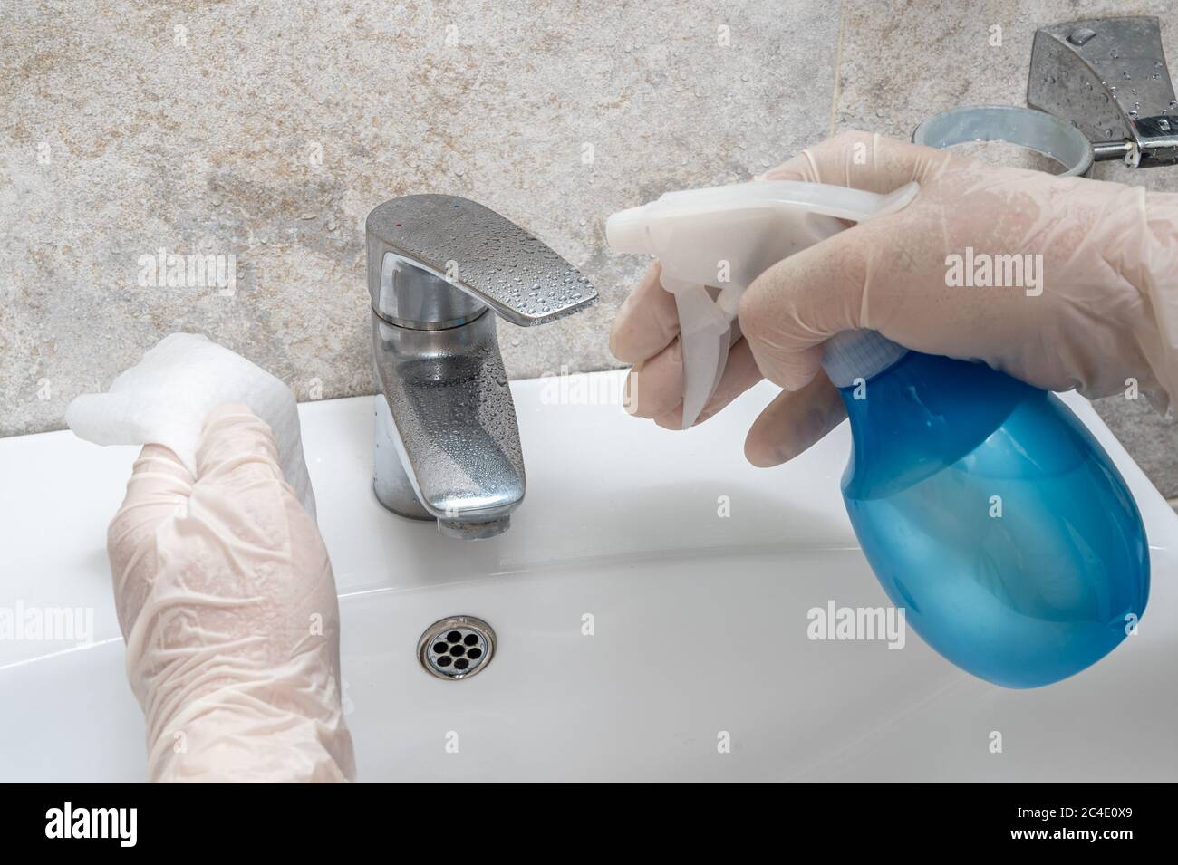 Desinfección del baño. Limpieza y desinfección del grifo. Prevención de la infección por coronavirus. Foto de stock