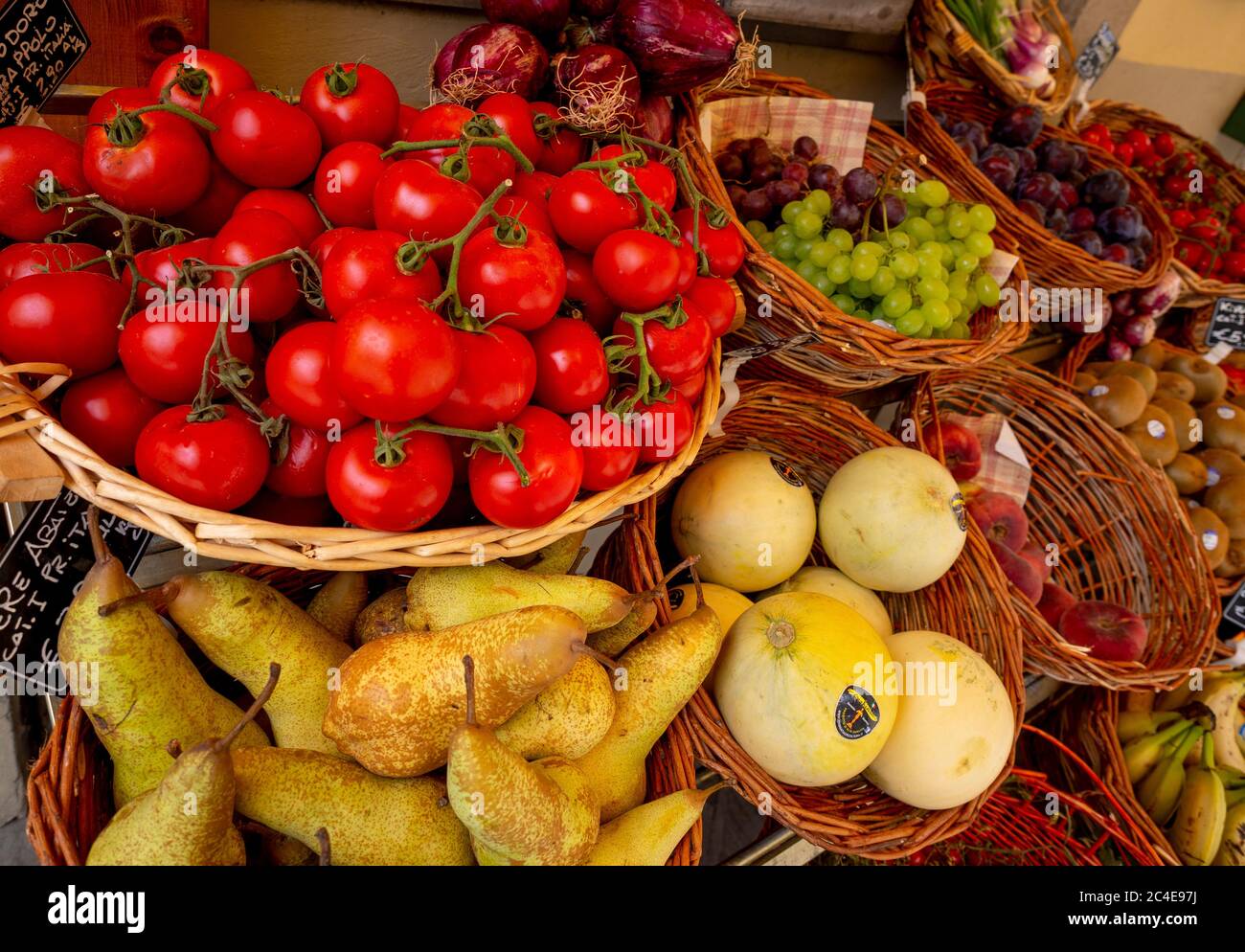 Frutas y verduras frescas que se muestran en las cestas fuera de un greengrocers italiano. Foto de stock