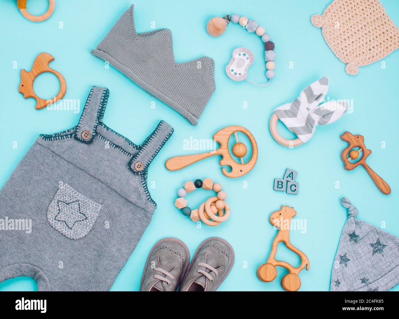 Concepto accesorios bebés. Ropa para y juguetes de madera sobre fondo azul claro. Vista superior, plano Fotografía de stock - Alamy