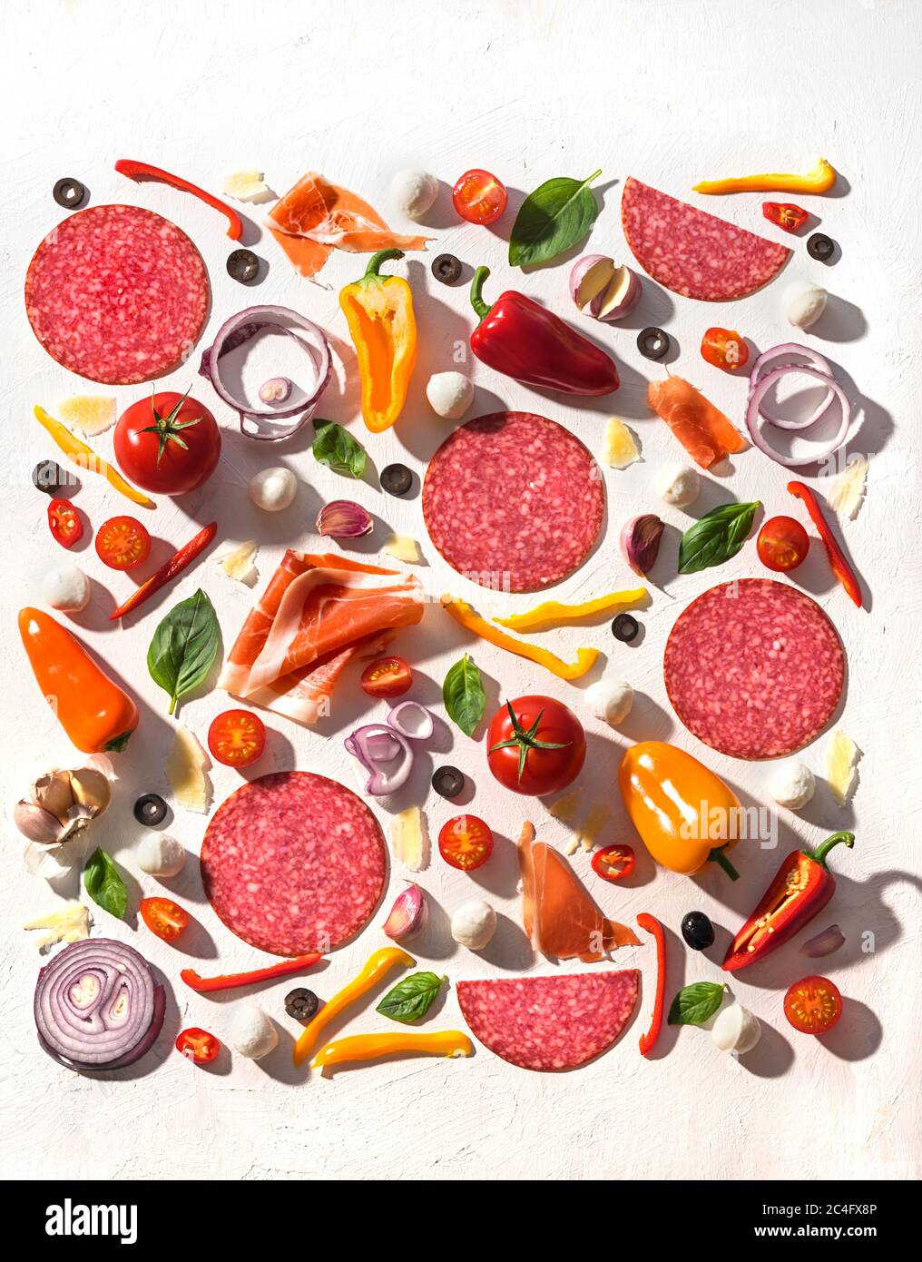 Concepto de Lay plano para la pizza tradicional italiana con ingredientes frescos, verduras, especias y carne sobre fondo blanco Foto de stock