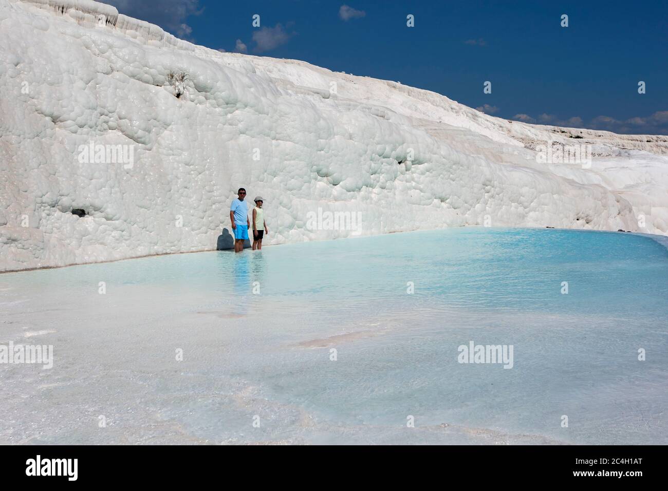 Un hombre y un niño se encuentran en una de las piscinas termales en los travertinos, o el castillo de algodón, en Pamukkale en Turquía. Foto de stock