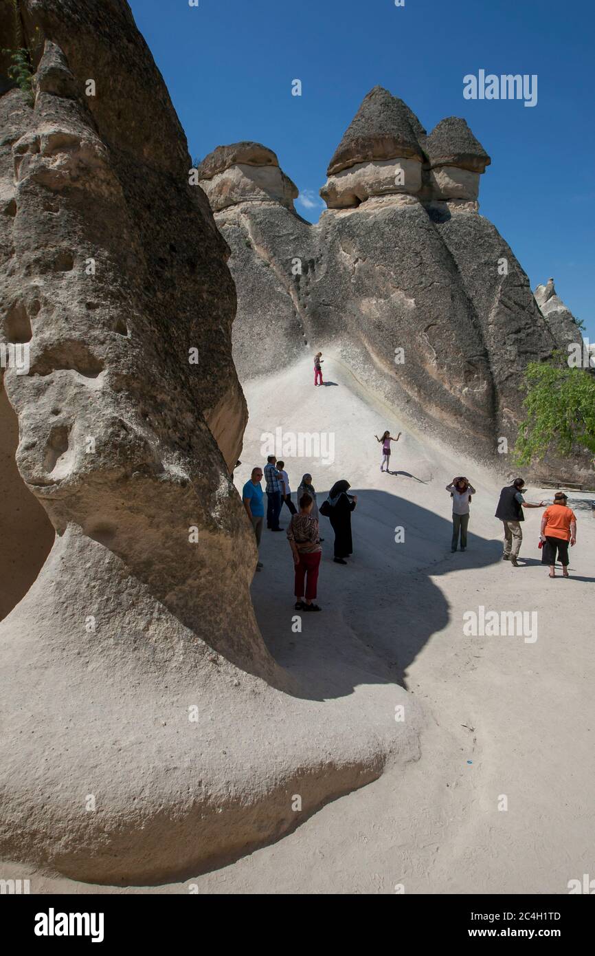 Los turistas admiran el paisaje único de la chimenea de hadas en Pasabagi cerca de Zelve en la región de Capadocia en Turquía. Foto de stock