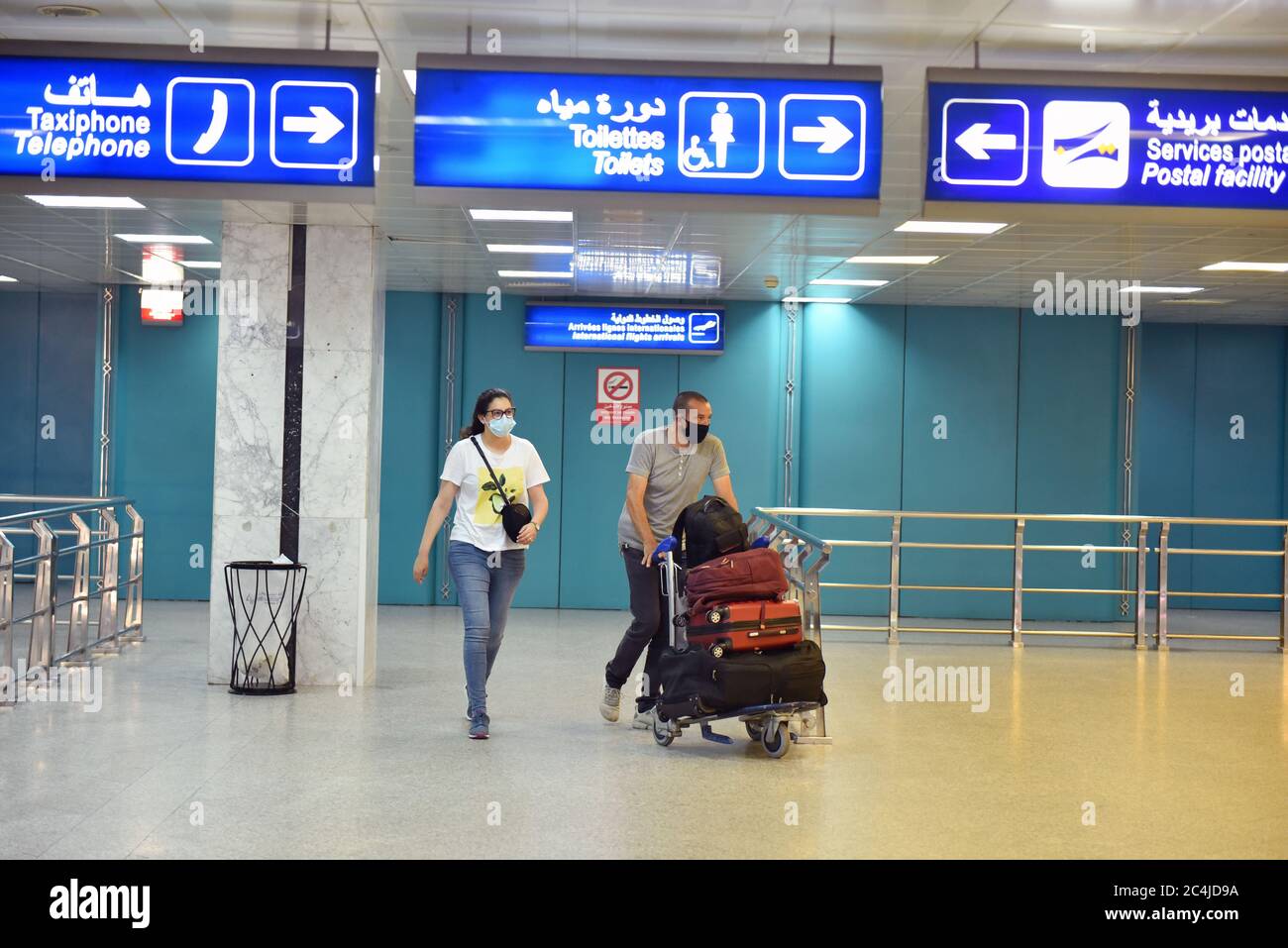 Personas que llevaban máscaras faciales como medida preventiva en el aeropuerto de Túnez-Cartago.Túnez reabrió sus fronteras terrestres, marítimas y aéreas por primera vez en más de tres meses el sábado después de que anunciara que había puesto bajo control el brote de coronavirus. Algunas operaciones se reanudaron en el aeropuerto de Túnez-Cartago, con vuelos a Roma, Ginebra y París programados para salir. El gobierno puso fin a todas las restricciones a la circulación y a las empresas después de que el primer ministro Elyes Fakhfakh dijera el 14 de junio que Túnez había ganado la batalla contra la propagación del virus. Foto de stock