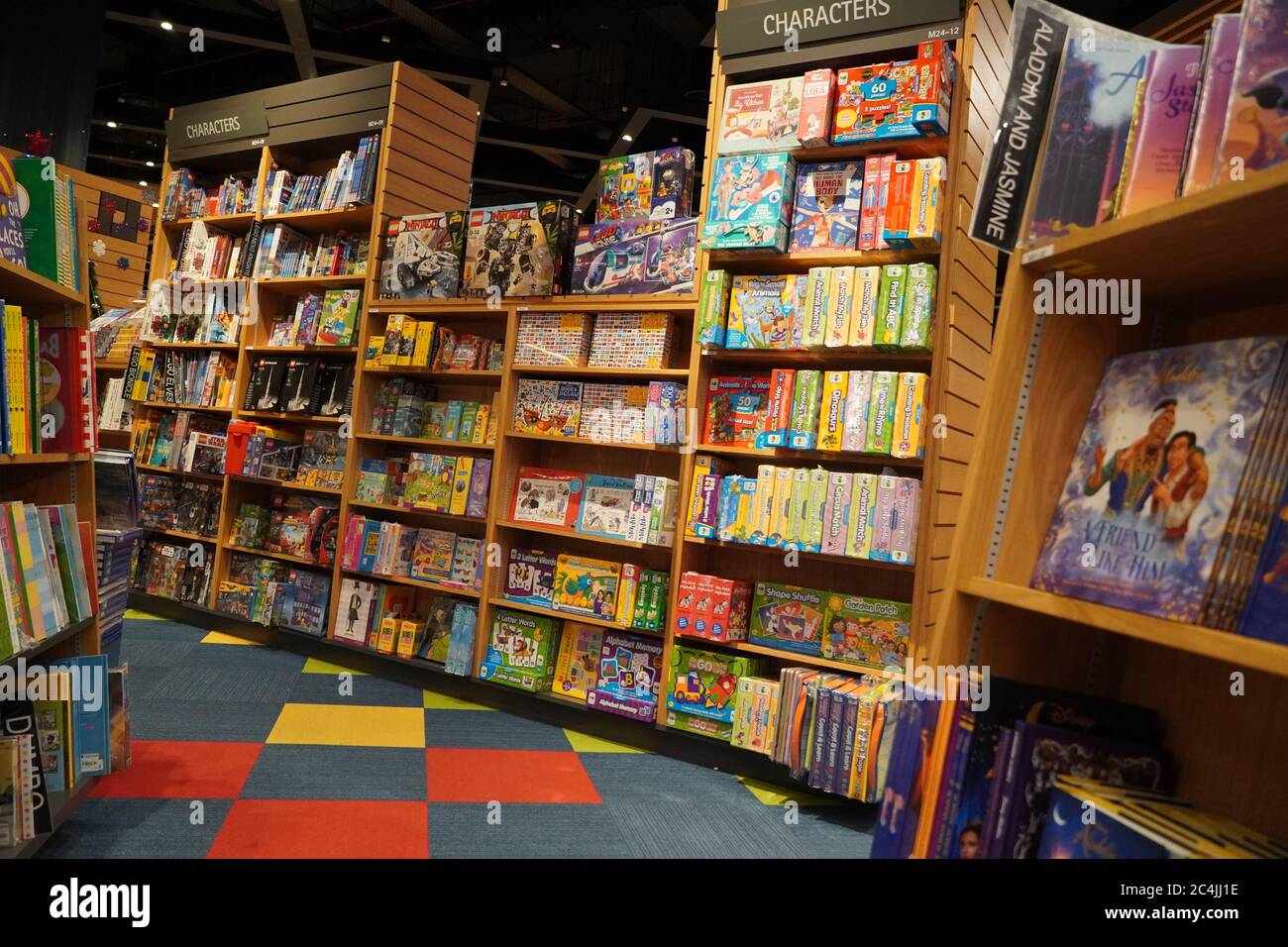 Los niños dibujando y coloreando libros en estanterías en una librería para  la venta. Biblioteca sección de libros para niños. Variedad de libros para  la venta en estante de libros en la