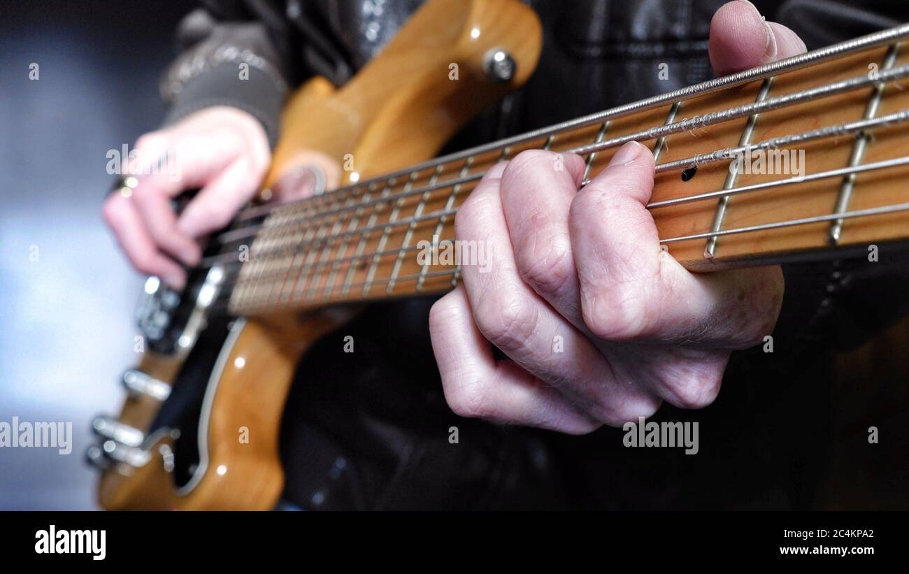 Guitarrista en chaqueta de cuero tocando un eléctrico de 5 cuerdas guitarra  Fotografía de stock - Alamy