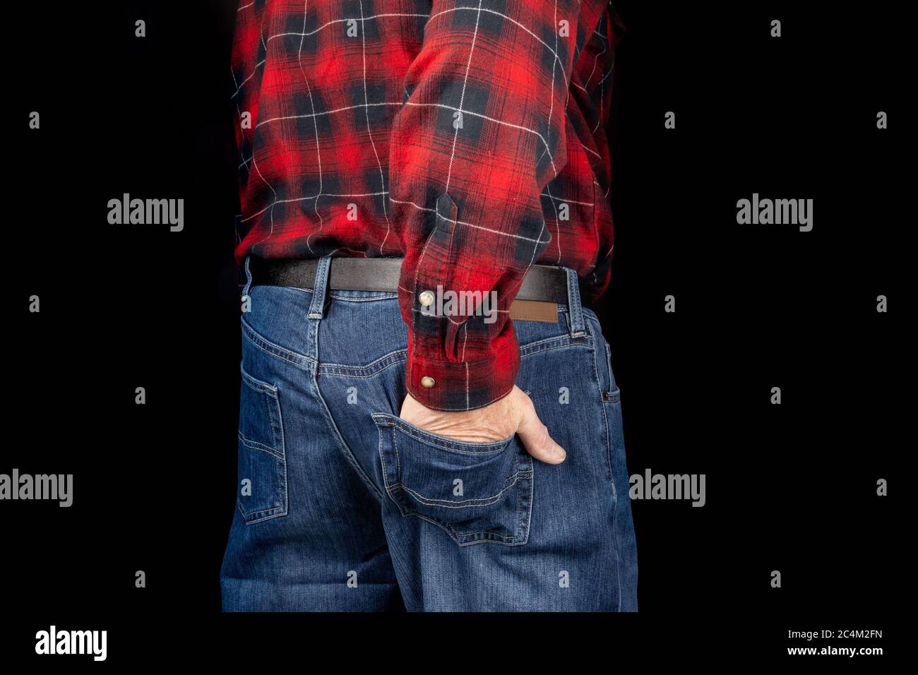 un hombre con jeans de color azul y una camisa roja una mano en el bolsillo trasero sobre negro Fotografía de stock - Alamy