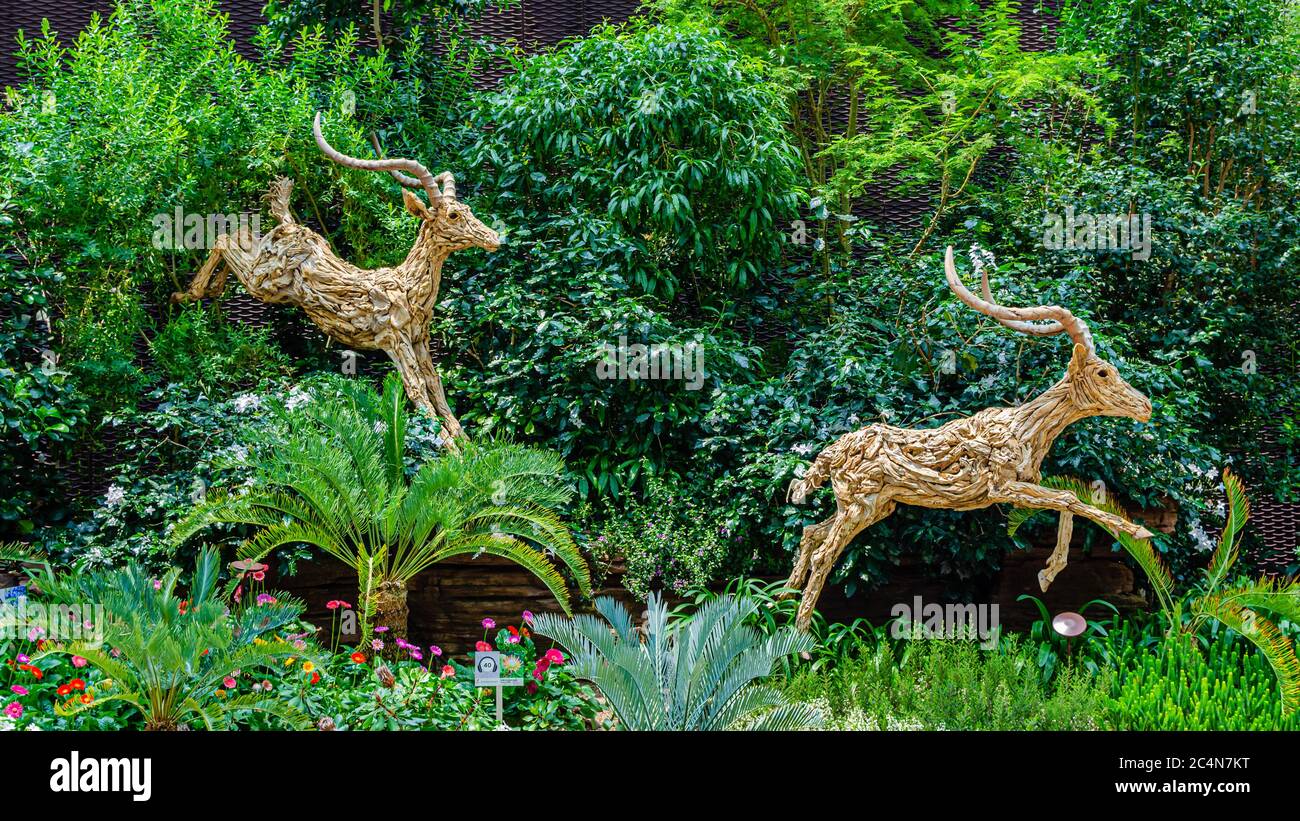 Tallado en madera de antílopes en los Jardines de Singapur junto a la Bahía cúpula de flores Foto de stock