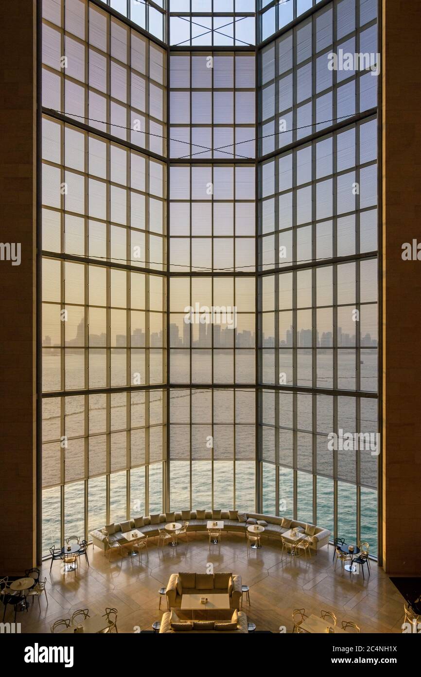 La puesta de sol de la ciudad de Doha tiene vistas a través de las grandes ventanas del Museo de Arte Islámico, Doha, Qatar Foto de stock