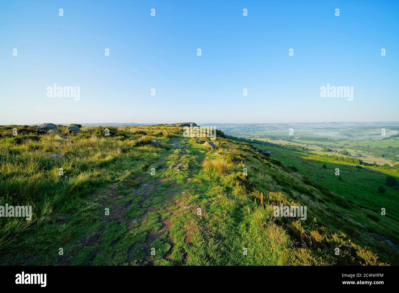 El sol de la mañana ilumina Baslow Edge y la campiña de Derbyshire Foto de stock