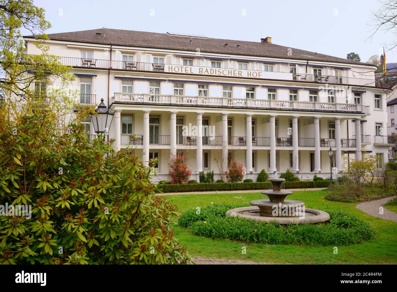 Hotel Badischer Hof en Baden-Baden, Alemania. Arquitectura histórica con el símbolo de la ciudad del centro de salud: La fuente de agua termal de tres cuenco. Foto de stock