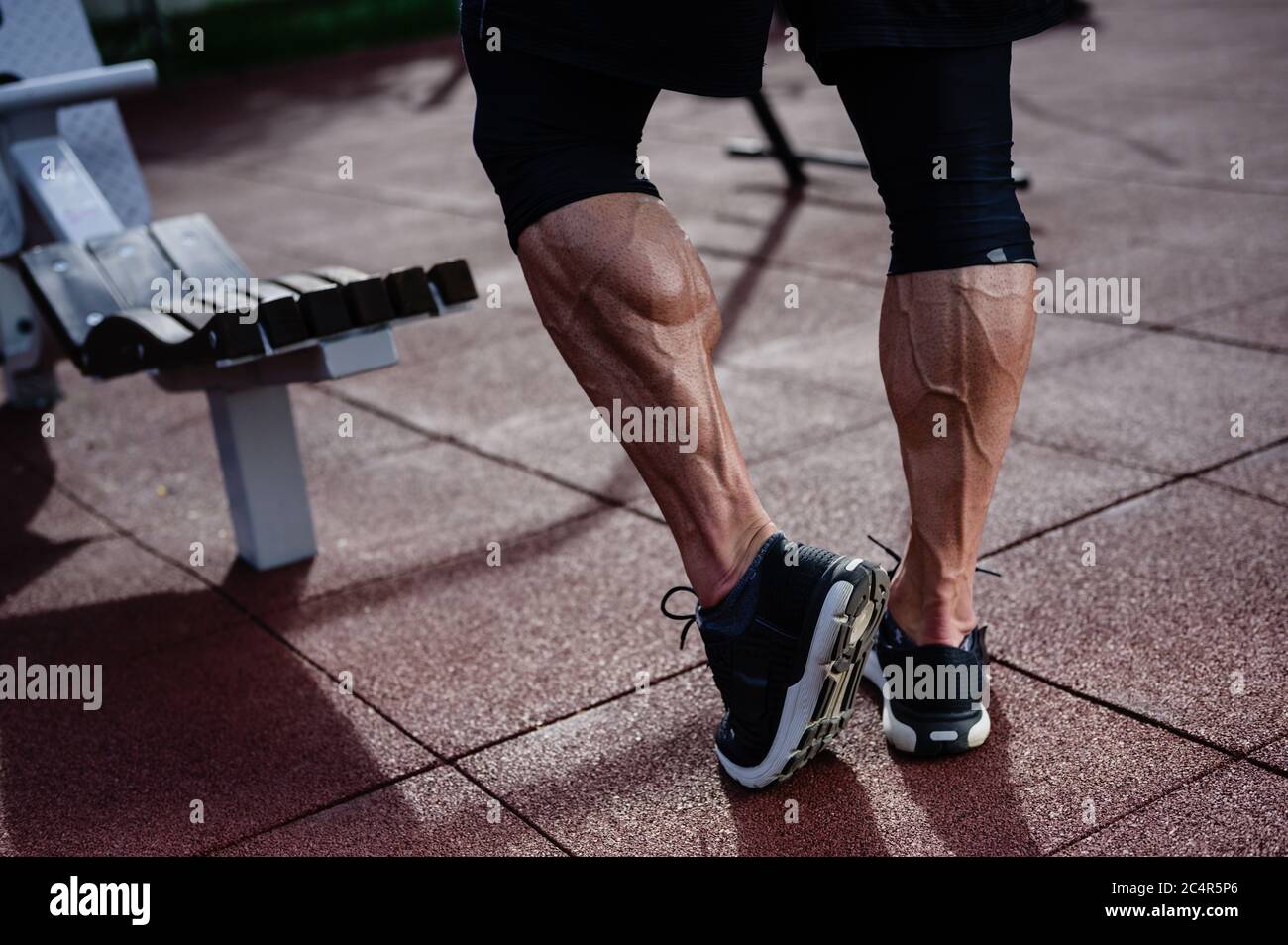 piernas de atleta fuerte de hombre en zapatillas de deporte de  entrenamiento al aire libre en el campo de deporte en verano Fotografía de  stock - Alamy